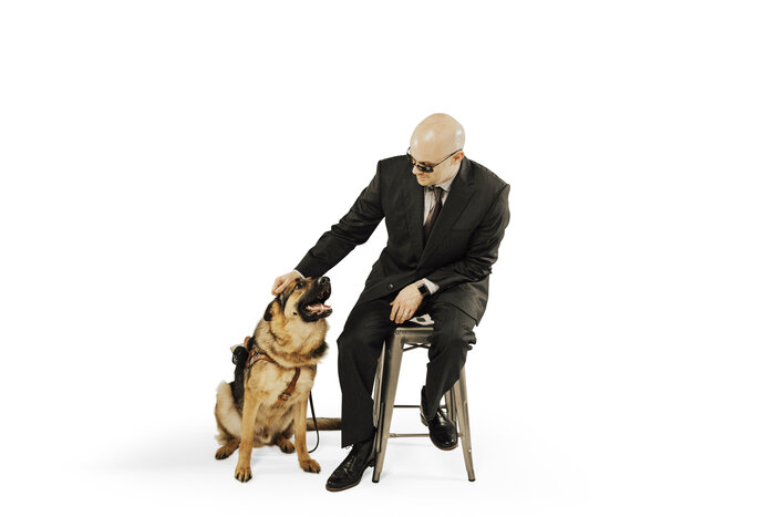 Chad E Foster smiling with his guide dog Sarge, demonstrating leadership and independence
