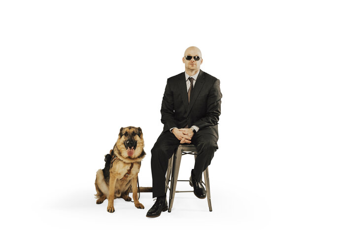 Professional photo of Chad E Foster with guide dog Sarge in business setting