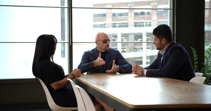 Chad E Foster in business meeting with medium framing showing professional interaction