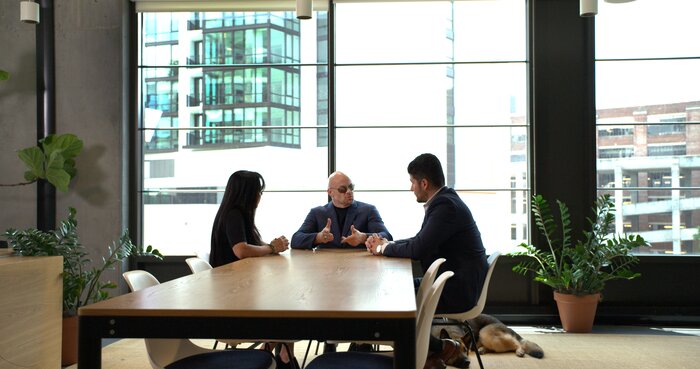 Wide shot of Chad E Foster leading business meeting in corporate boardroom