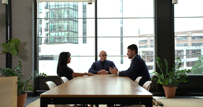 Wide angle corporate meeting with Chad E Foster providing leadership consultation