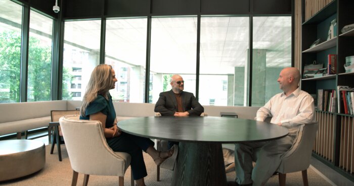 Boardroom wide shot showing Chad E Foster facilitating strategic business meeting