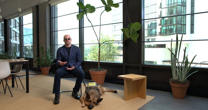 Casual photo of Chad E Foster with his guide dog, showing personal side